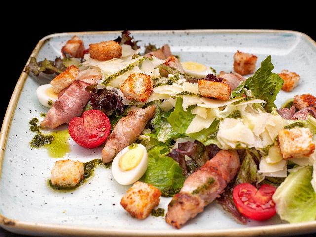 Caesar salad with chicken fillet in bacon