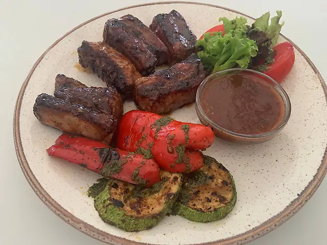 Pork ribs on fire with grilled vegetables