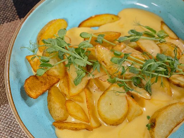 Картофельные дольки под сырным соусом