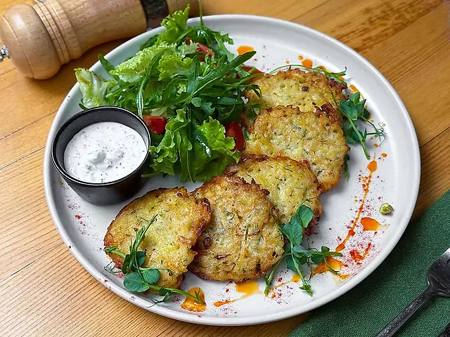 Драники из картофеля с зеленым салатом и соусом дзадзыки