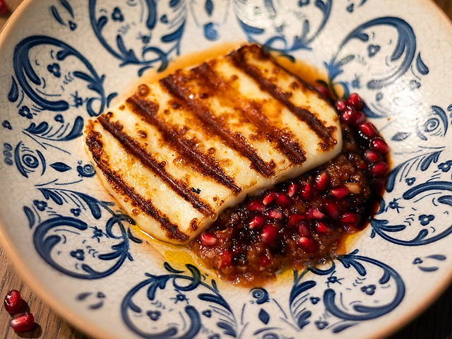 Халумі на грилі з ікрою із баклажанів, сиропом із фініків та гранатом