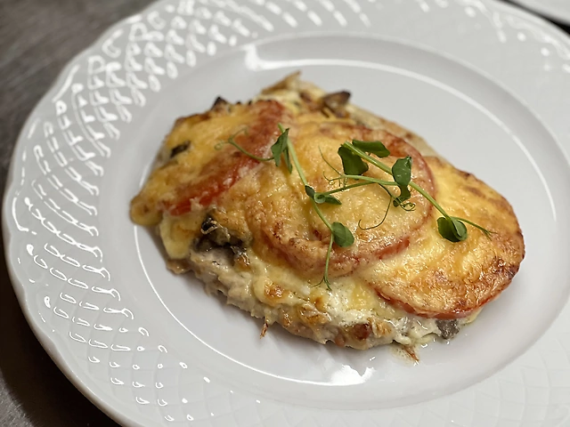 М'ясо по-французьки зі свинини з сиром, грибами та помідорою