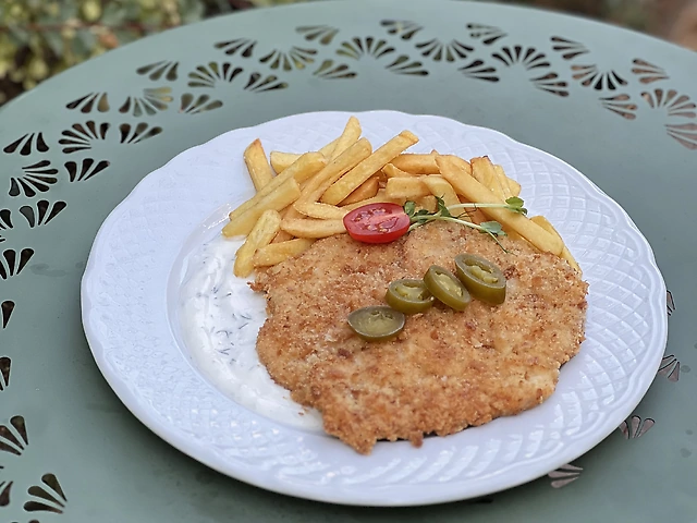 Свинячий шніцель у паніровці з йогуртом та перцем халапеньо