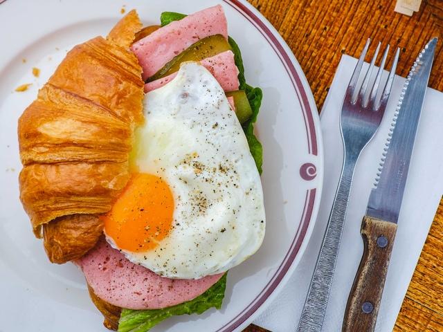 Круассан с поджаренной докторской колбасой и глазуньей