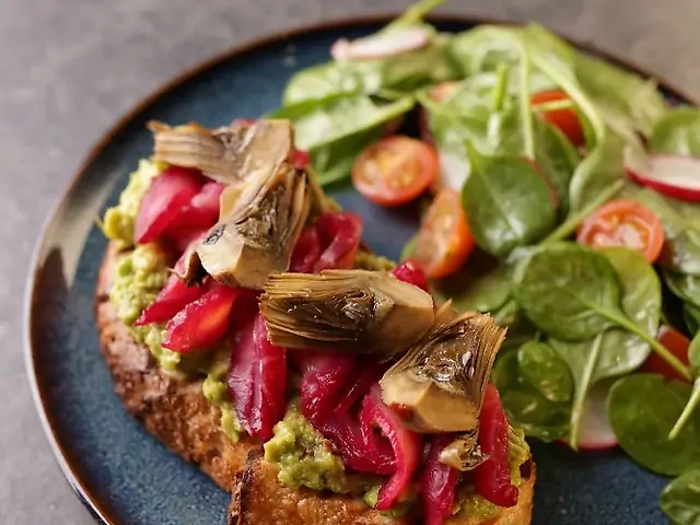 Toast with guacamole and salmon gravlax and artichokes