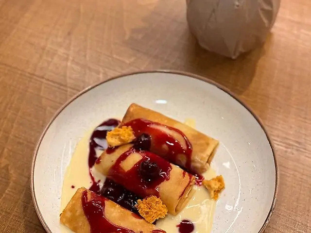 Млинці з солодким сиром з ванільним кремом та вишневим соусом