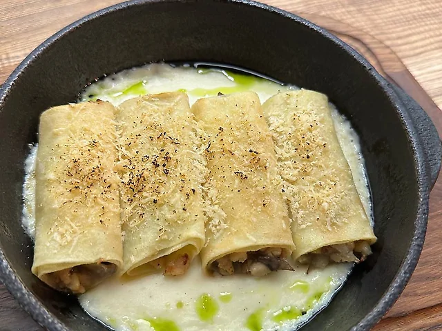 Млинці з куркою та грибами запечані в соусі бешамель.