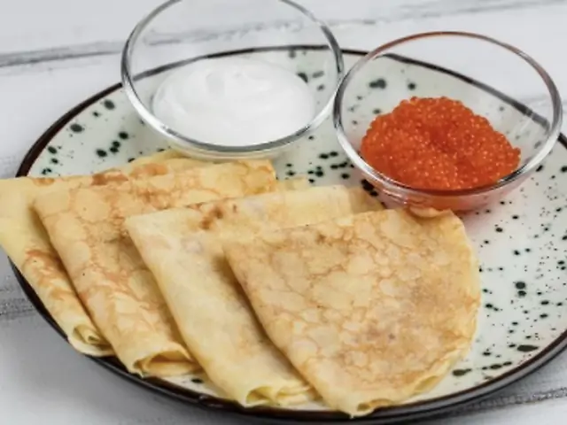 Червона ікра кети власного посолу з тонкими млинцями та сметаною