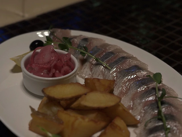 Оселедец з картопляними скибочками та маринованною цибулею